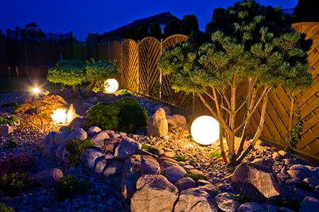 Home garden at night, illuminated by globe shaped lights